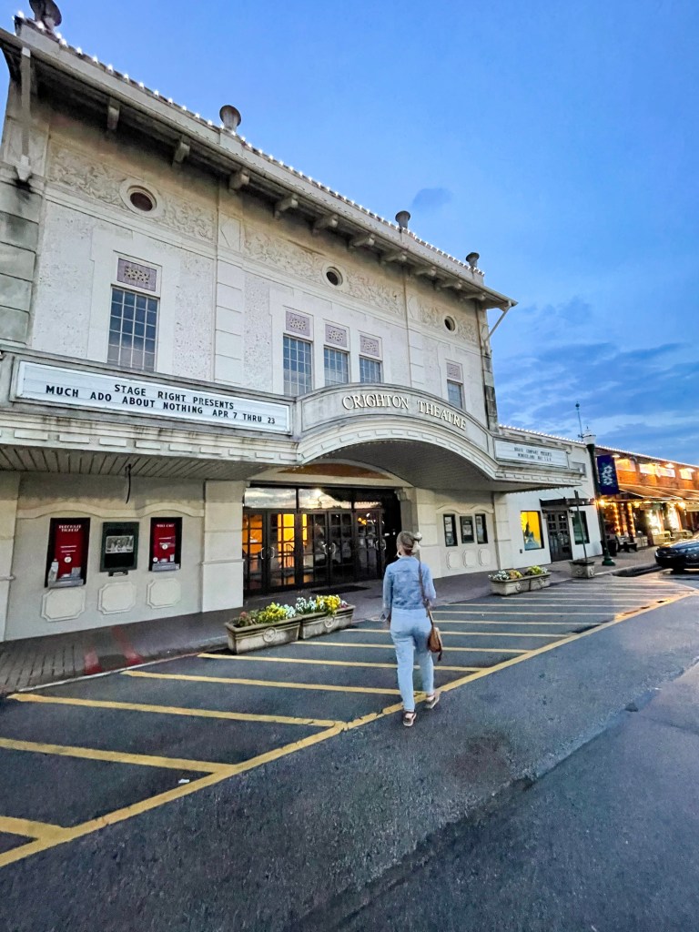 Woman walking towards Crighton Theatre, a historic theatre in Conroe, Texas