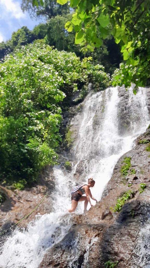 Women climbing up a waterfall in El Salvador