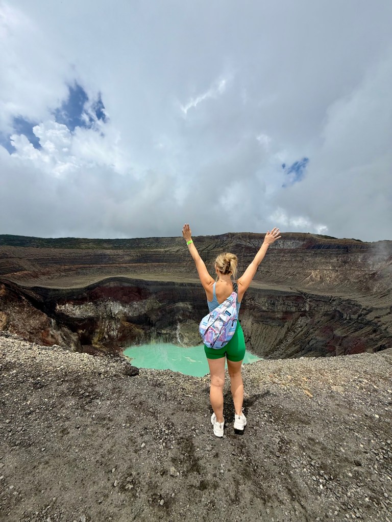 Woman standing on top of the Santa Ana Volcano in El Salvador overlooking the crater lake