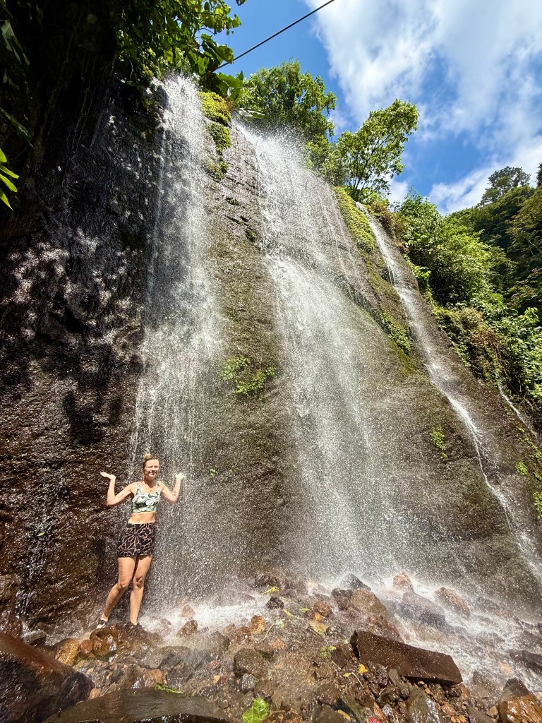 Women standing under a waterfall in El Salvador